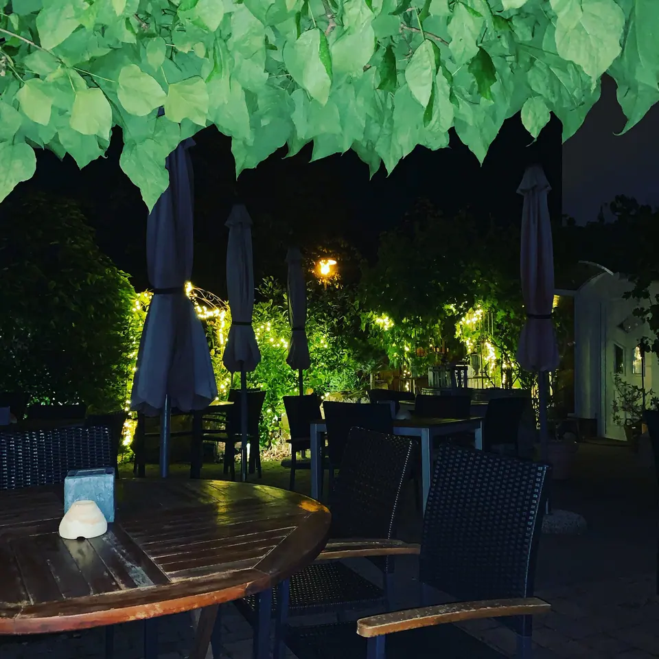 Gedeckte Tische im Hof am Abend