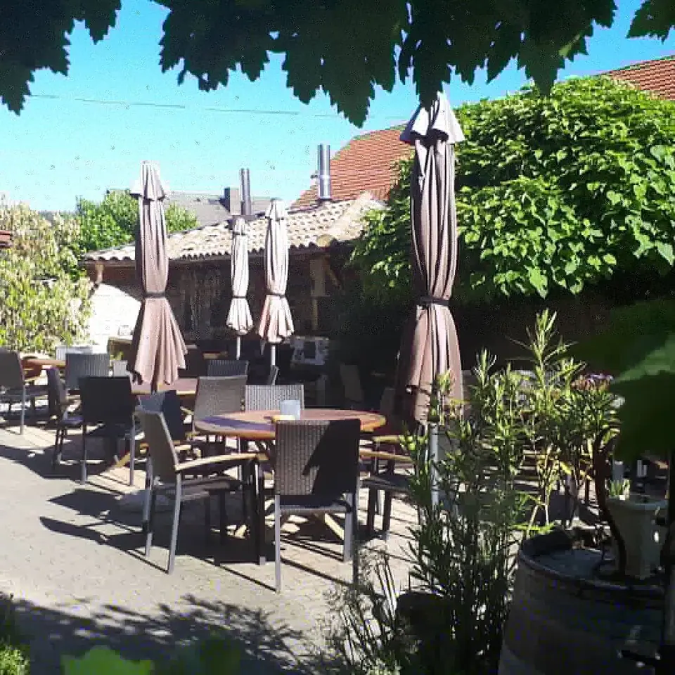 Sitzplätze im Hof unter Sonnenschirmen