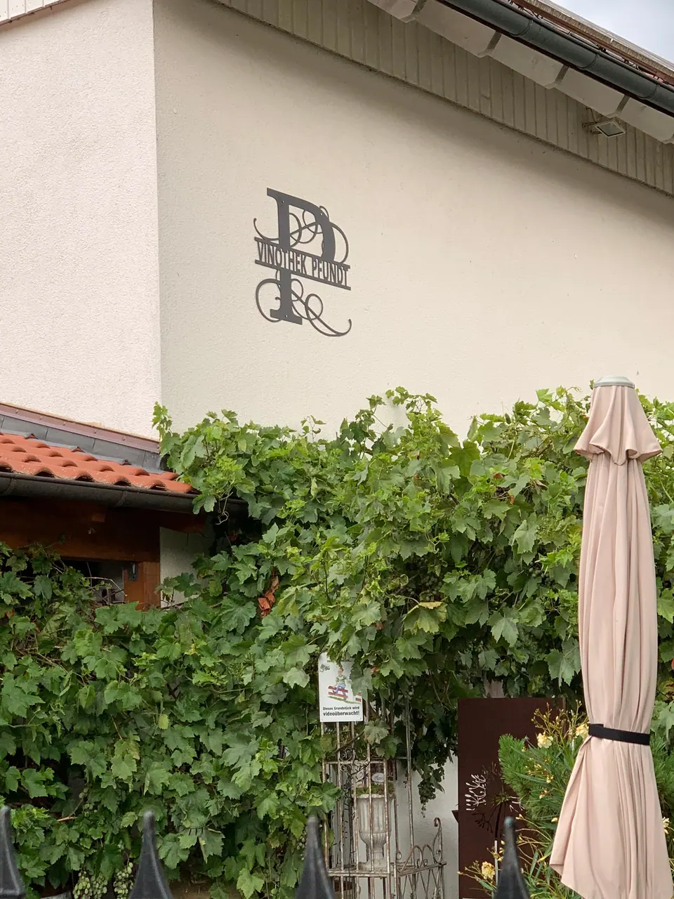 Schmiedeeisernes Monogramm Vinothek Pfundt an der Hauswand